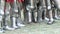 Many pairs of male legs in iron knight armor at the festival of reconstructing a historical battle