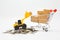 Many parcel boxes in a shopping cart , loader and coins heap on white background for  online shopping concept