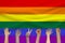 Many people`s hands on the background of the LGBT rainbow flag, Pride flag, Freedom flag - the international symbol of the lesbia