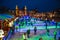 Many people skate on winter ice skating rink at night in front of the Rijksmuseum, a popular touristic destination in Amsterdam