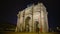 Many people walking by triumphal arch in Place du Carrousel, night Paris, France