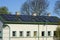 Many photovoltaic solar panels mounted on the old large wooden house roof