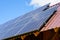 Many photovoltaic solar panels mounted on wooden house roof, roof of solar cells