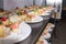 Many plates of appetizers being prepared in commercial kitchen, for an event, selective focus