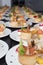 Many plates of appetizers being prepared in commercial kitchen, for an event, selective focus