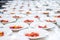 Many plates dish of tomato red salad being prepared in commercial industrial professional kitchen galley for event party