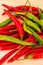 Many pods of long chili peppers green red contrasting fruits base bright contrasting on a wooden base