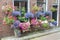 Many pottery flowers hanging at brick wall