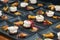 Many prepared appetizers of feta cheese and rhubarb with sprout garnish arranged on black plates for a festive gourmet menu,
