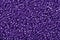 Many purple glass cane beads, background.