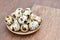 Many Quail eggs in a plate on old wooden table