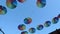 Many rainbow colour umbrellas hanging overhead on blue sky background