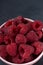 Many raspberries in a plate on a black background Stacked image Still life photography