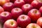 Many red apples on a wooden background.