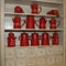 Many Red Coffee Makers and Red Metal Tea Containers on a Shelf