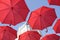 Many Red umbrellas against the blue sky. View from below. Abstract background with red umbrellas.