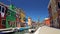 Many relaxed people strolling in colorful streets on Burano island, summer rest