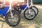 Many retro fat electric bicycle scooters parked on dirt grass field outdoor ready for hire rental sharing cpuntry parl