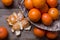 Many ripe mandarins in a basket. One peeled and divided into lobules