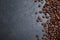 Many roasted coffee beans on black table, flat lay. Space for text