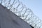 many rows of barbedwire, high concrete fence, barbed wire fence on top, building for execution of punishments for criminals,