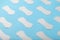 Many Sanitary pads on a blue background in the form of a diagonal pattern. Textured background all over the screen