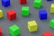 Many scattered colorful toy cubes on gray background