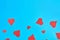 Many scattered red paper hearts on blue background. Concept of Valentines Day