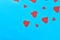 Many scattered red paper hearts on blue background. Concept of Valentines Day