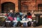 Many school backpacks. A pile of backpacks and bags lie on the grass and bench. some things left in a sunny public park