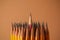 Many sharp graphite pencils on brown background