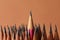Many sharp graphite pencils on brown background, closeup