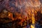 Many sharp stone spikes on the surface of the ceiling inside the Damlatas cave in Alanya Turkey. Natural brown-orange-blue