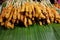 Many skewers pork satay on green banana leaves annd sellinng