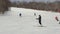 Many skiers and snowboarders coming down slope snow-covered mountain on skis