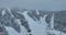 Many skiers and snowboarders skiing down on snowy mountainsides slopes in mountains at ski resort in winter. Family and