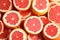 Many sliced fresh grapefruits as background