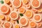 Many sliced fresh grapefruits as background, top view. AI generation