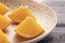 Many slices of orange on a black wooden table in a brown dotted plate