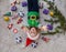 Many small gift boxes and Christmas tree decorations lies around joyful toddler girl in Santa hat and elf`s sweater