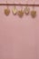 Many small hearts carved from wood hang pinned to pink wooden background. Copy space, place for your text. Valentin`s day concept