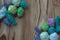 Many small multicolor melange cotton yarn balls for knitting, crochet. Wooden rustic background