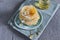 Many small pancakes with honey or syrup. Delicious traditional breakfast. Spring flowers as food styling in photography. Gray