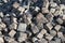 Many small paving stones in a pile, ready to be processed for cobblestone paving of a street. Close-up.