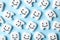 Many small plastic teeth with cute faces on color background