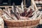 many smoked sausages and salami in wooden basket on table at street food festival. catering outdoors, open kitchen, summer picnic