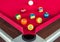 Many snooker balls or pool balls near the corner hole on red table