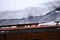 Many snow on a roof top of a house