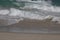 Many splashing waves rushing to the sand