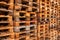 Many stacks of used  wooden pallets of euro type on warehouse is ready for recycling. Industrial background. Close-up